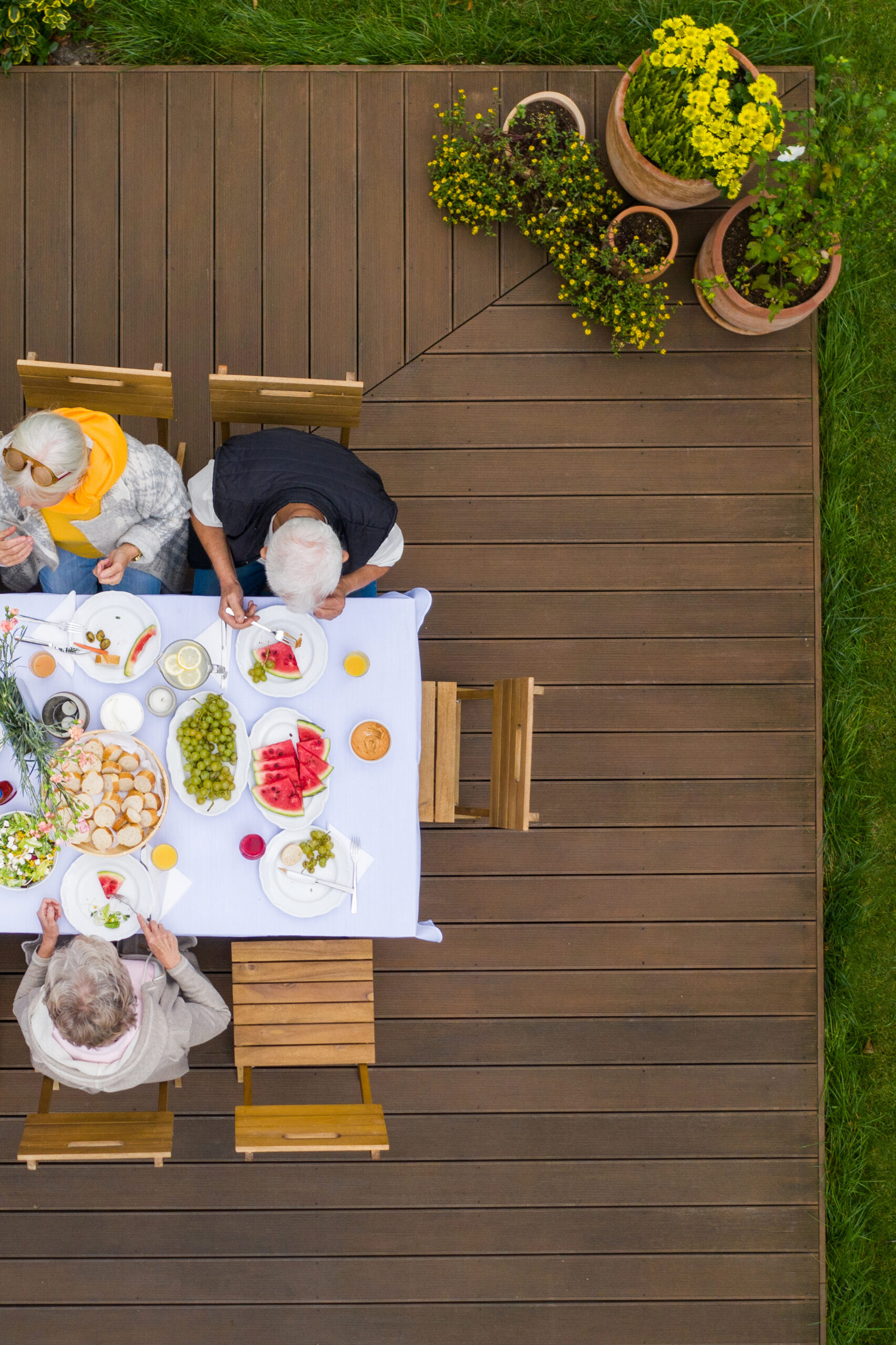 Top view of terrace with table full of food and seniors sitting